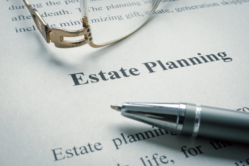 Close-up of a pen and eyeglasses resting on an estate planning document.